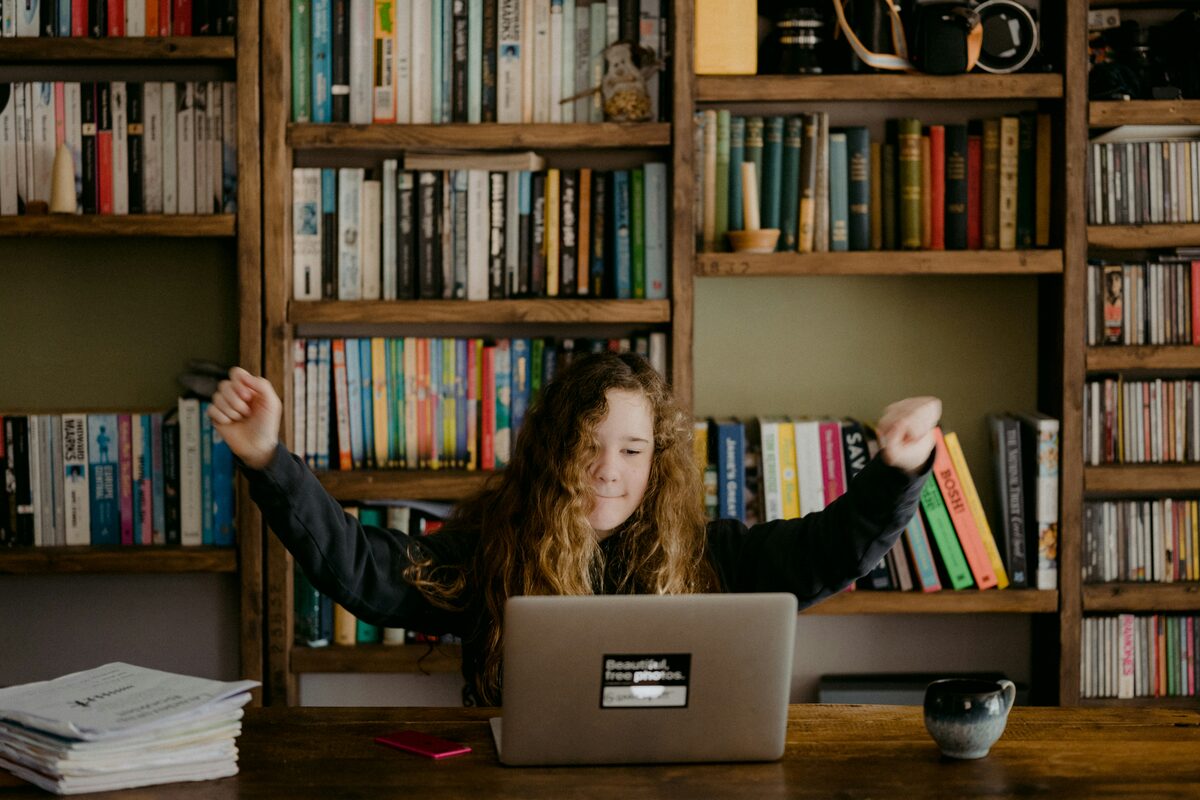 A student celebrating at her laptop