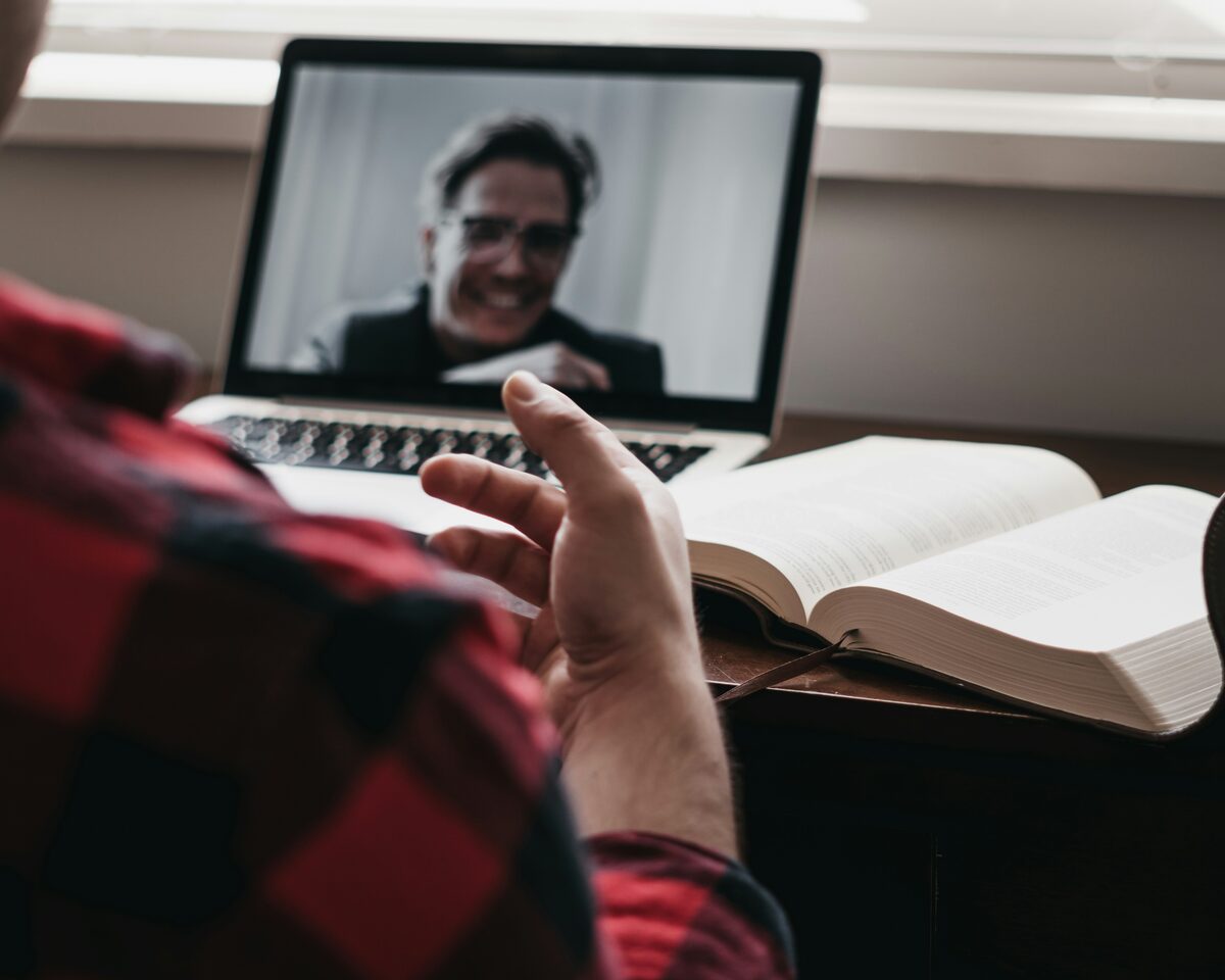 A smiling tutor giving an online lesson to a student